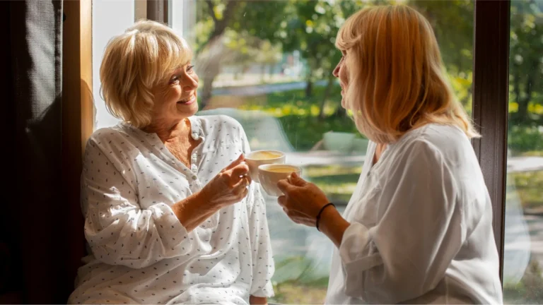 Senior client reading with Vitalcare Support carer nearby